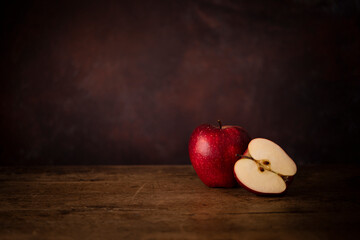 One Whole Apple and One Half Apple on a Wooden Old Surface. Kitchen Table Concept