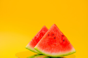Watermelon in a cut. Slices of watermelon on a bright yellow background. Appetizing summer fruits. 