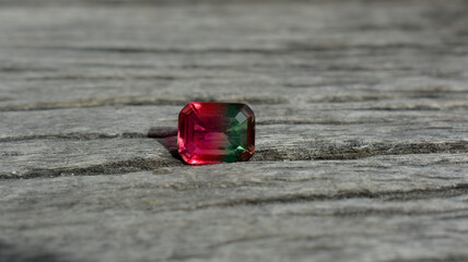 A beautiful red gem or ruby is placed on the ground.
