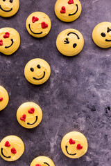 Several smiley face emoticon merengue cookies scattered around with copy space.