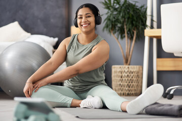 Create healthy habits for yourself. Portrait of a sporty young woman stretching her legs while exercising at home. - Powered by Adobe