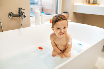 Naklejka premium Cheerful child posing for the camera in the bathroom