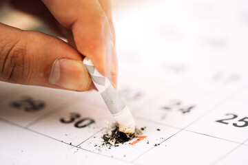 Hand puts out cigarette about 31 days in calendar close-up.