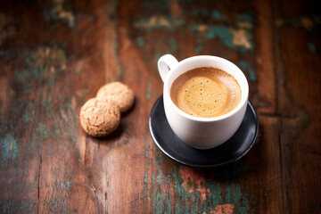 Cup of coffee with Amaretti (Italian biscuits) on rustic wooden background. Copy space.