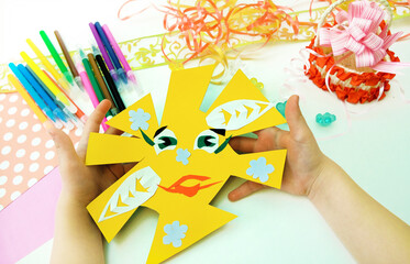 DIY crafts. Child preparing  for Mothers Day, making greeting card. Girl making paper sun as gift...