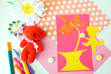 Child preparing  for Mothers Day, making greeting card. Girl making paper flower as gift for Mothers day, Birthday or Valentines day . Arts  crafts concept.