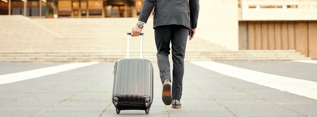 Making my way downtown. Shot of a businessman walking around town with his luggage.