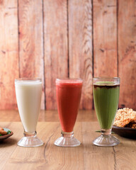 Freshly blended fruit smoothies of various colors and tastes in tall Glass. White, Red, Green.