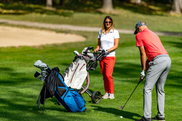 Obraz premium Young couple playing golf on a beautiful summer day