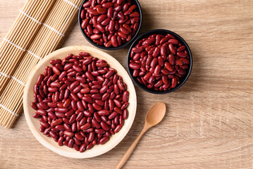 Red kidney bean on plate and bowl with spoon on wooden background, Table top view