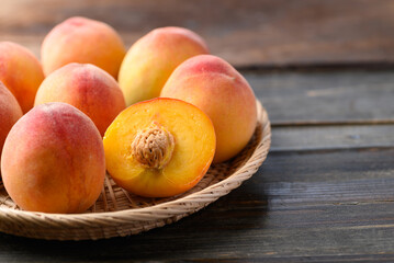Peach fruit in basket on wooden background