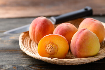 Peach fruit in basket on wooden background
