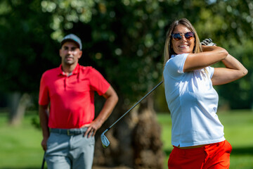 Two golfers, female and male playing golf