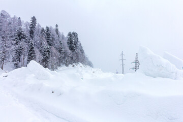 Winter mountain forest, snow-covered trees, panoramic views on the edge of the cliff, snow caps on the branches of the forest.