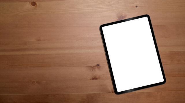 Mockup digital tablet with empty display on wooden background with copy space.