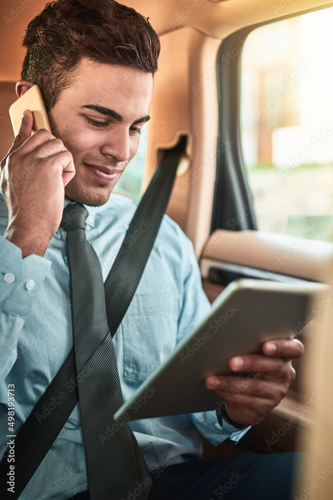 Aufkleber managing business on the go. shot of a young businessman talking on a phone while using a digital ta