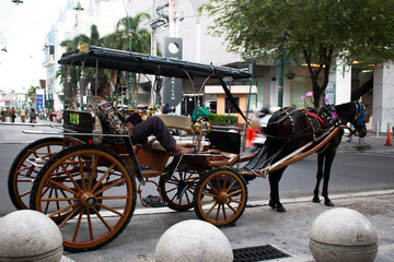 Yogyakarta, Indonesia April 2022: horse carriage driver in Yogya waiting for tourists along Malioboro street