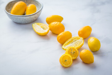 Small citrus fruits limequat with bowl on table