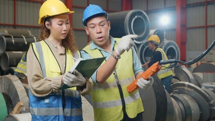 Supervisor senior man training controlling overhead crane with remote new worker in manufacturing, Engineering team use remote control panel for lifting down power trolley crane in factory warehouse