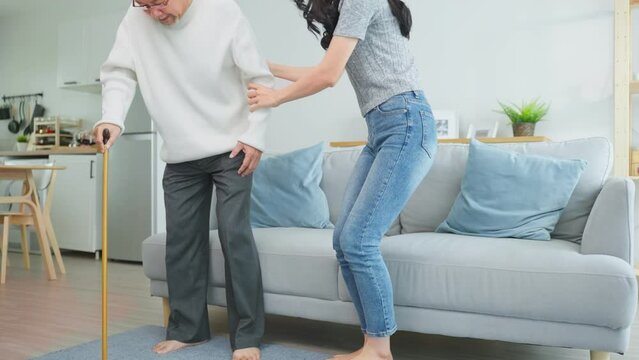 Asian young daughter support senior older man walk with walker at home