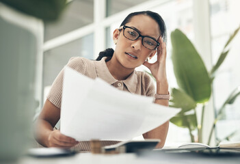 This is so complicated and confusing. Portrait of a young businesswoman looking stressed out while calculating finances in an office.