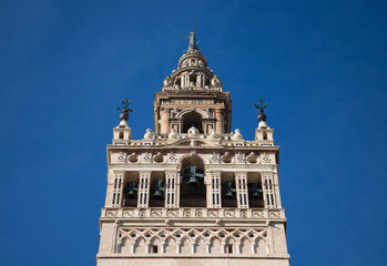 Fototapeta na wymiar Monument of the giralda of seville in the gothic cathedral. It can be seen rising into the blue sky of the city. It is the largest religious building in the world. Tourism and travel concept.