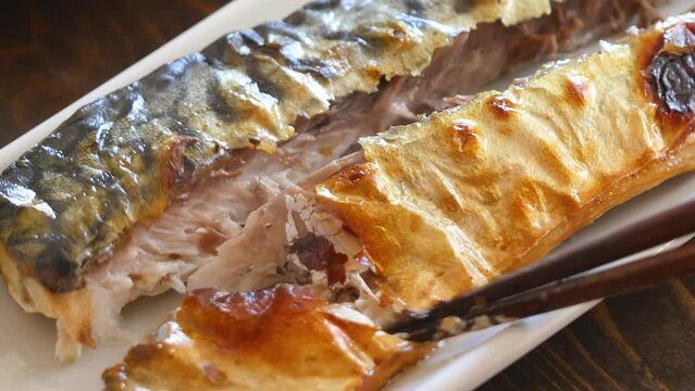 こんがりパリパリにグリルした焼き鯖のクローズアップ動画。健康的な朝食のおかず。	