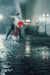 A couple dances in the evening in the rain. Blurred defocus. Focus on the foreground