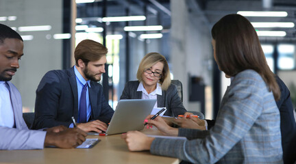 Group of happy young business people in a meeting at office.
