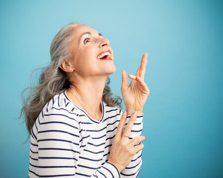 Happy woman gesturing against blue background