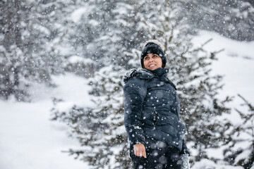 Smiling woman wearing knit hat enjoying snowfall
