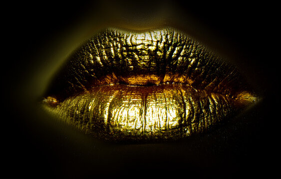 Gold lips. Gold Paint on mouth. Golden lips on woman mouth. Sensual sexy lip.