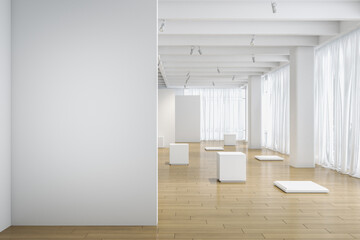 Fototapeta na wymiar Light blank wall in the foreground with copyspace for your text in empty modern light exhibition hall with white details and stands on natural color wooden floor. 3D rendering, mockup