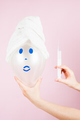 Concept with syringe and hand injecting a balloon. Non-invasive cosmetology concept