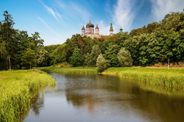 Fototapeta na wymiar Scenic view of pond in Feofaniya park in Kyiv, Ukraine. St. Panteleimon Convent mirrored in the water