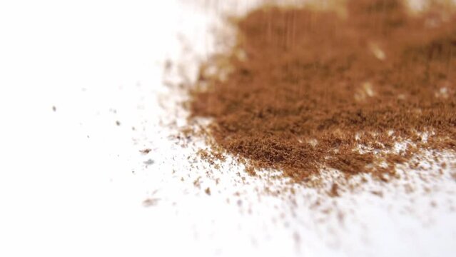 Instant roasted chicory root powder with cereal additives to replace traditional coffee drink. Organic herbal fragrant substitute on white background. Falling particles in slow motion. Macro. Rotation
