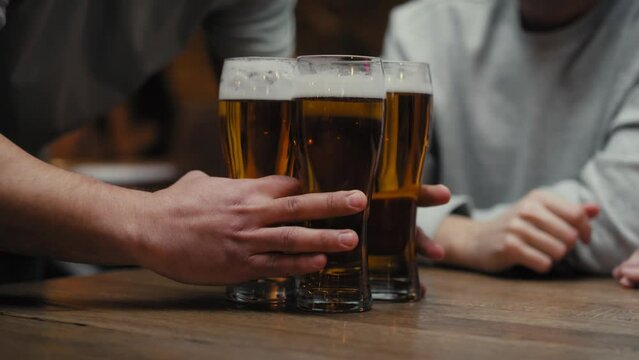 Close up of unrecognizable man bringing beer glasses for friends. Shot with RED helium camera in 8K. 