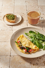 breakfast with eggs. vegetables and cup of turmeric latte. Morning sunny light