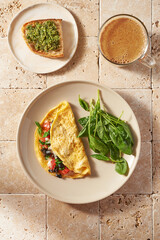 breakfast with eggs. vegetables and cup of turmeric latte. Morning sunny light