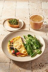 breakfast with eggs. vegetables and cup of turmeric latte. Morning sunny light