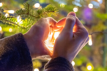 希望の光　クリスマスイルミネーションを優しく包む手　The ray of hope ; The christmas light wrapped with gentle hands