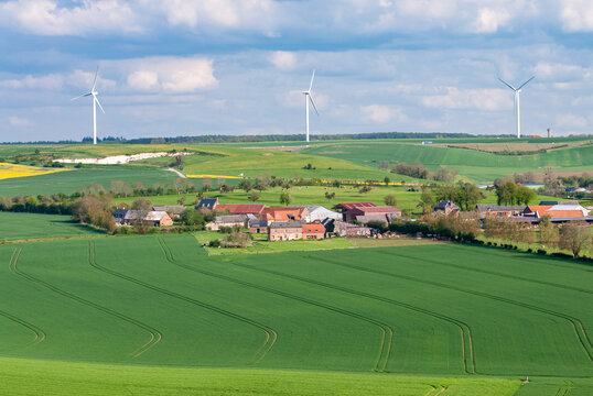 Paysage du pays de Bray, village au milieu des champs. Parc &eacute;olien en arri&egrave;re-plan