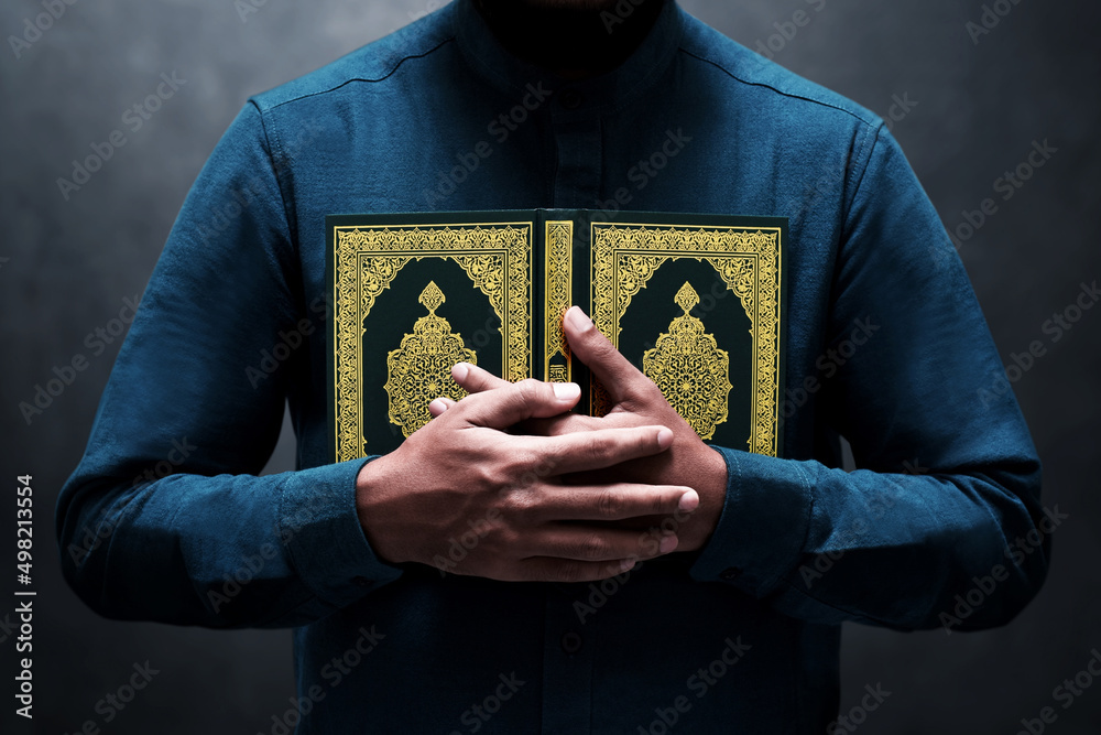 Wall mural muslim man holding holy quran