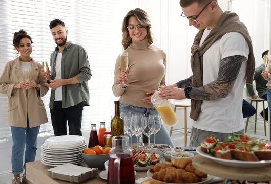 Group of people enjoying brunch buffet together indoors - Powered by Adobe