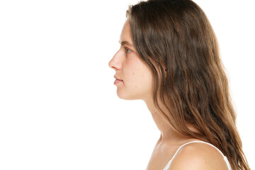 Profile of a young woman without makeup on a white background