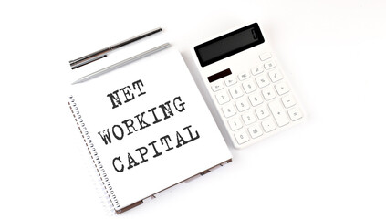Notepad with text NET WORKING CAPITAL with calculator and pen. White background. Business