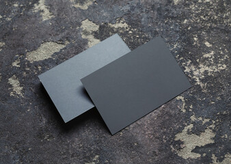 Photo of blank grey business cards stack on concrete background. Branding mock up.
