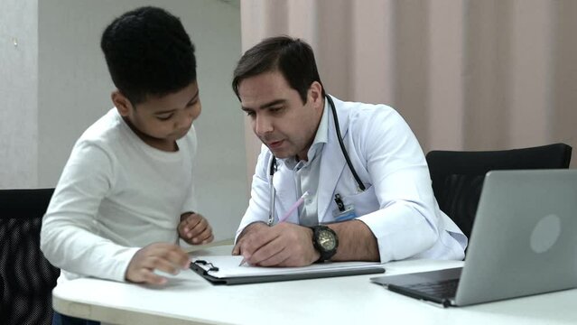 A doctor at an international hospital Trying to check up of a mischievous child in the hospital's OPD examination room.
