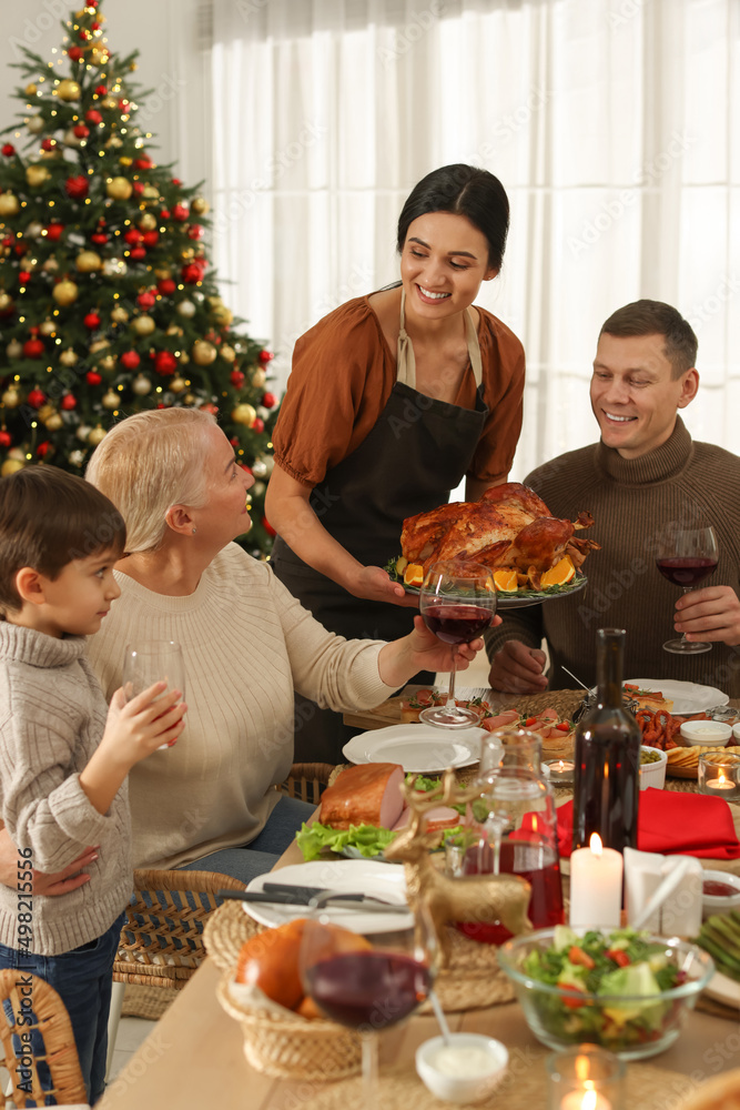 Wall mural Happy family enjoying festive dinner at home. Christmas celebration