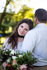 Portrait of a happy bride and groom, in boho style wedding dresses, against the backdrop of beautiful nature